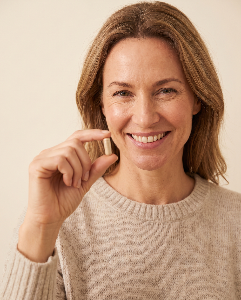 Smiling woman holding a Zenovyx capsule